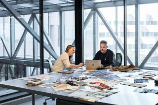 Twee ontwerpers overleggen in modern kantoor