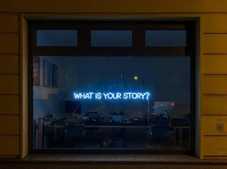 Blauwe neonletters What is your story