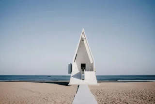 Witte kerk aan het strand met zee op achtergrond